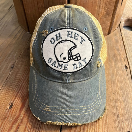 Vintage-style cap with 'Oh Hey Game Day' logo on a wooden surface