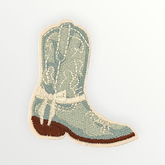 Embroidered patch of a cowboy boot on a light gray background