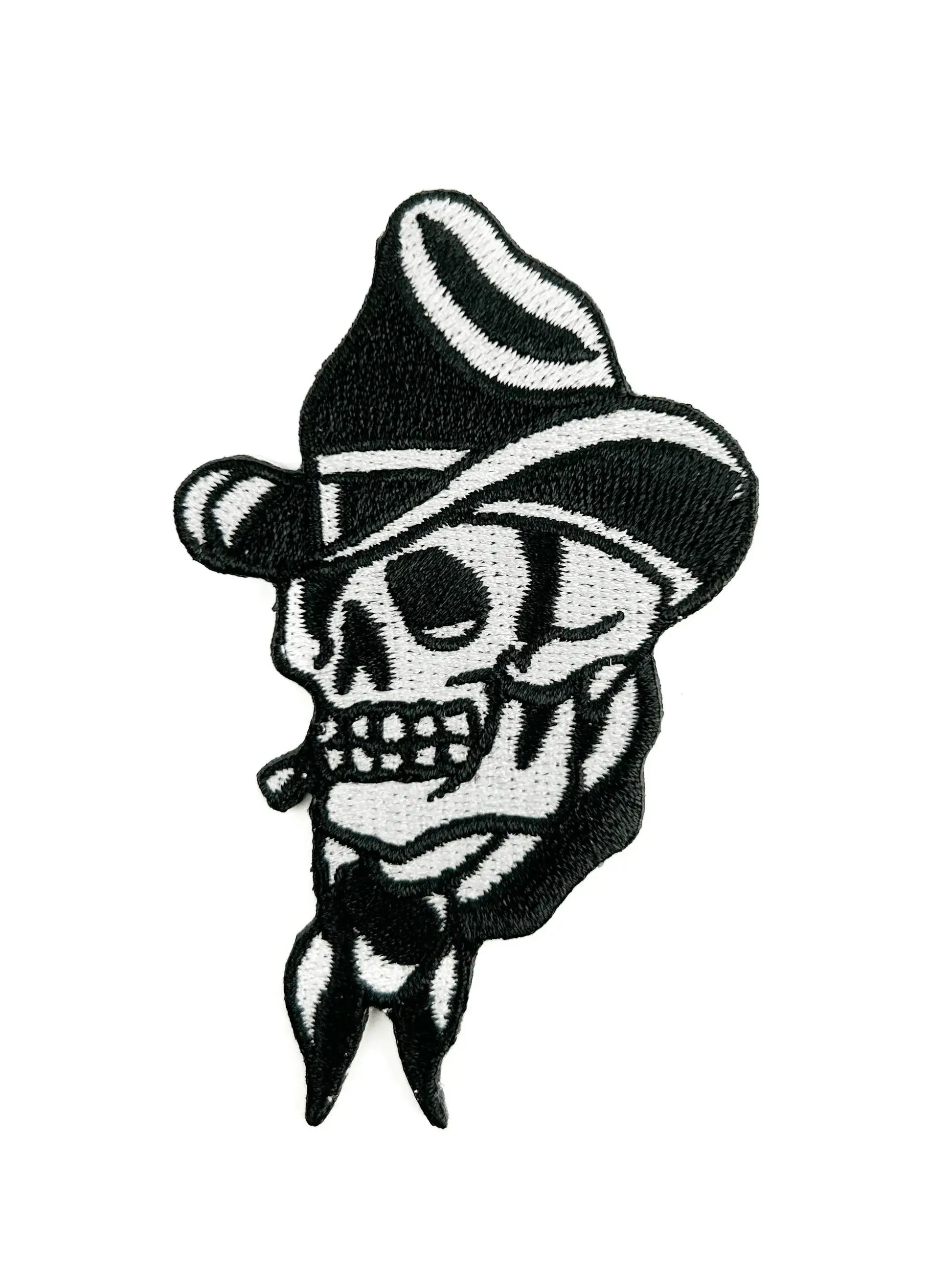 Black and white skull patch with a cowboy hat on a white background