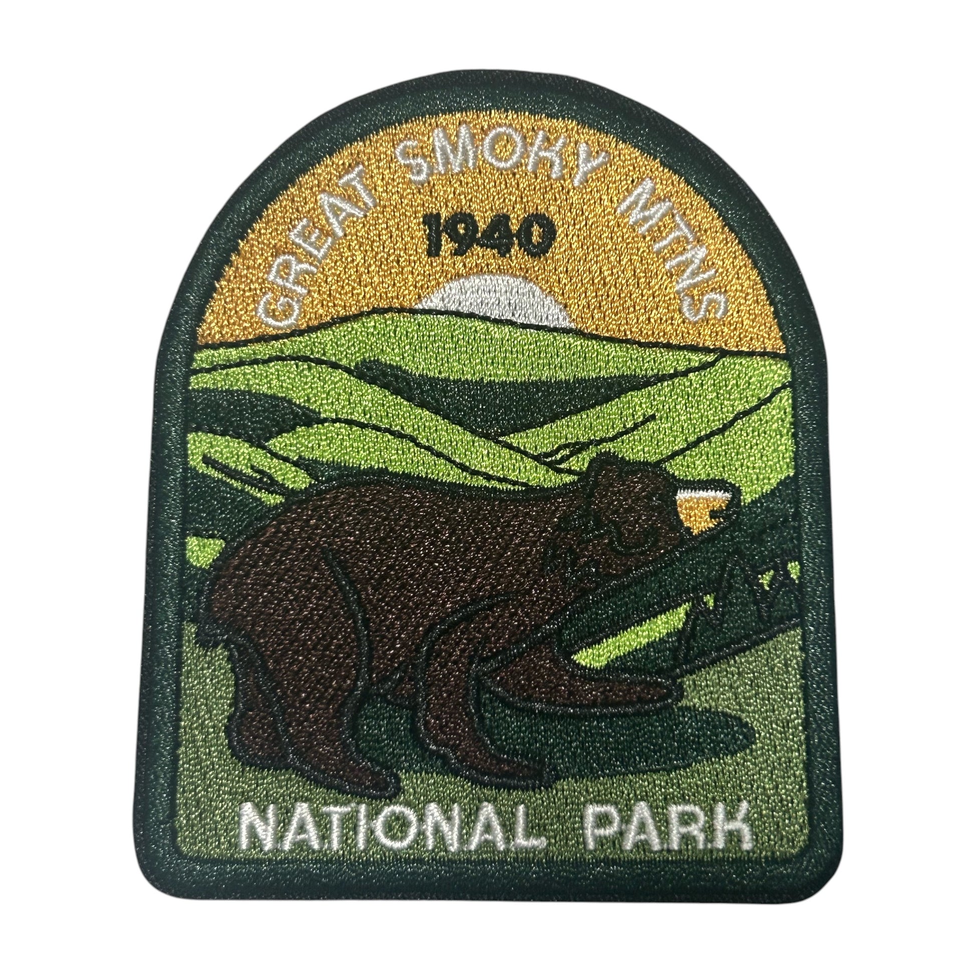An embroidered patch for Great Smoky Mountains National Park, featuring a brown bear in the foreground, green hills, a yellow sky with 'GREAT SMOKY MTNS 1940' text, and 'NATIONAL PARK' at the bottom.