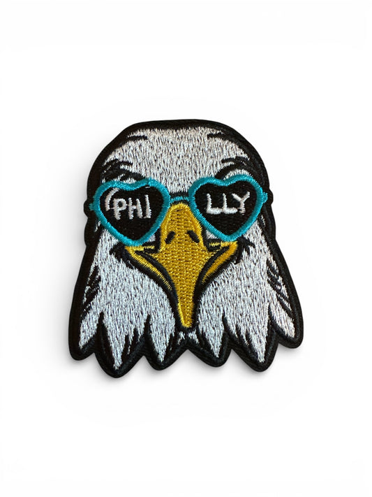 Eagle patch with heart-shaped sunglasses and 'PHILLY' text on a white background