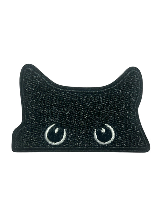 A black cat-shaped patch with embroidered white eyes, shown on a plain white background.