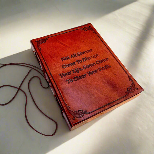 Red leather notebook with engraved text on a light surface