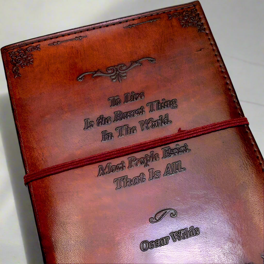 Brown leather notebook with embossed text on a white surface