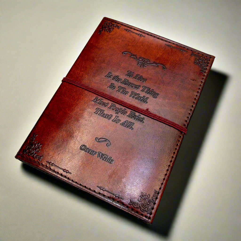 Brown leather notebook with embossed text on a light gray background