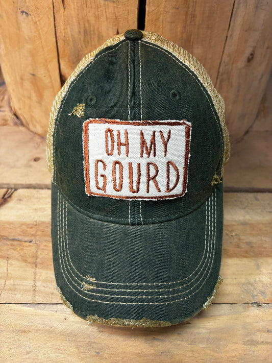 Green cap with 'Oh My Gourd' patch on a wooden surface