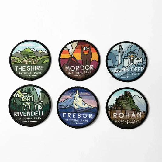 Set of six circular patches from Lord of the Rings with various locations and text on a white background. Shire National Park; Mordor National Park; Helms Deep; Rivendell National Park; Erebor; Rohan
