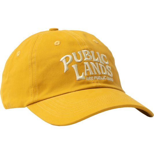 A yellow cotton baseball cap with 'PUBLIC LANDS ARE PUBLIC GOOD' embroidered in white on the front, shown against a plain white background.