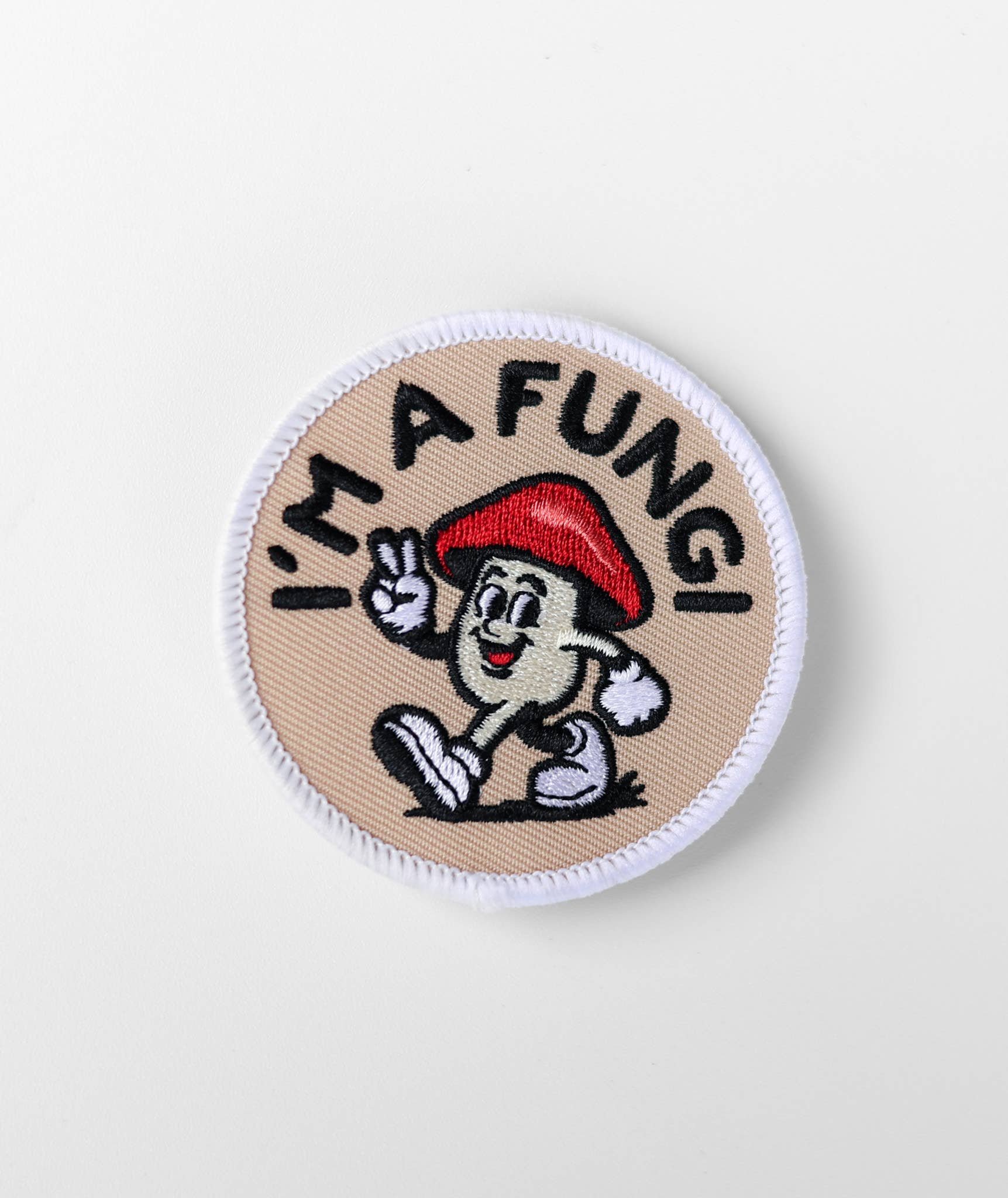 Circular patch with cartoon mushroom character and 'I'm a Fungi!' text on a beige background
