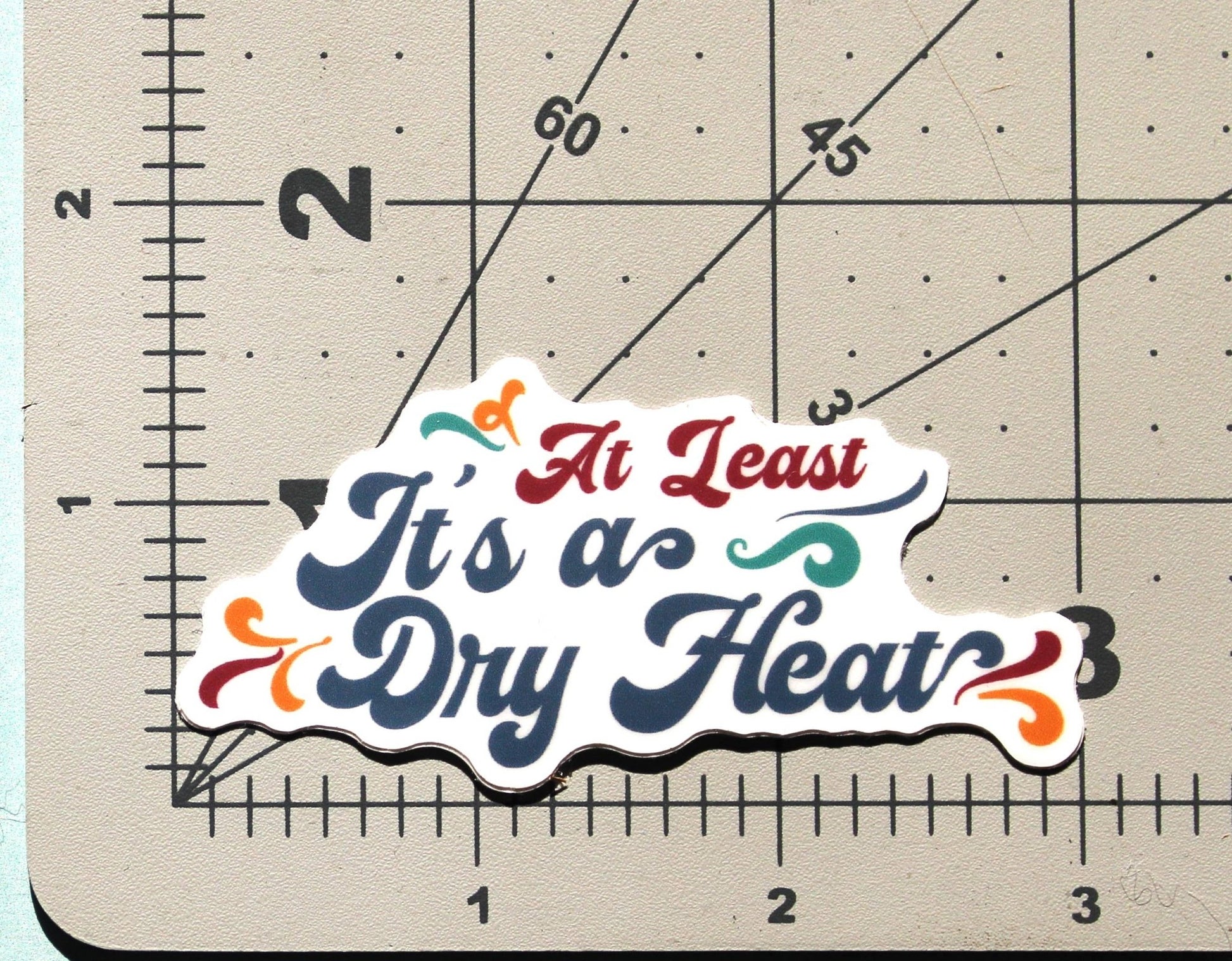 "At Least It's A Dry Heat" Vinyl Sticker 3" Wide - Wander Together Outfitters