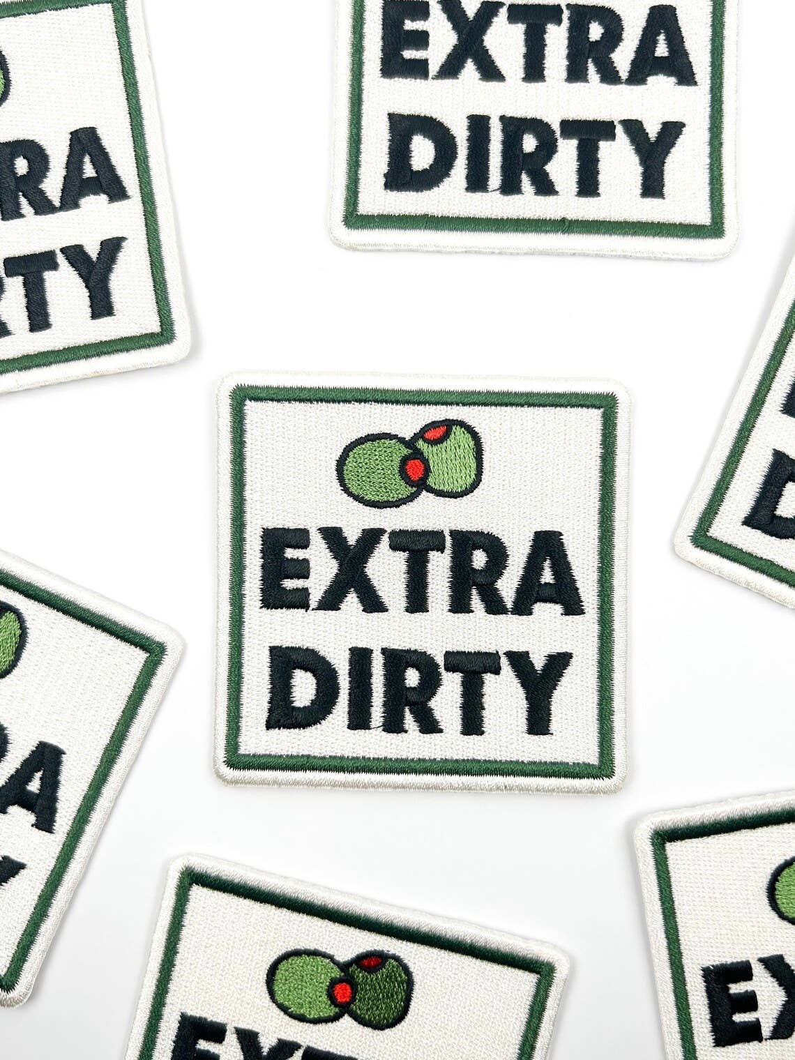 Multiple 'Extra Dirty' patches with a logo on a white background