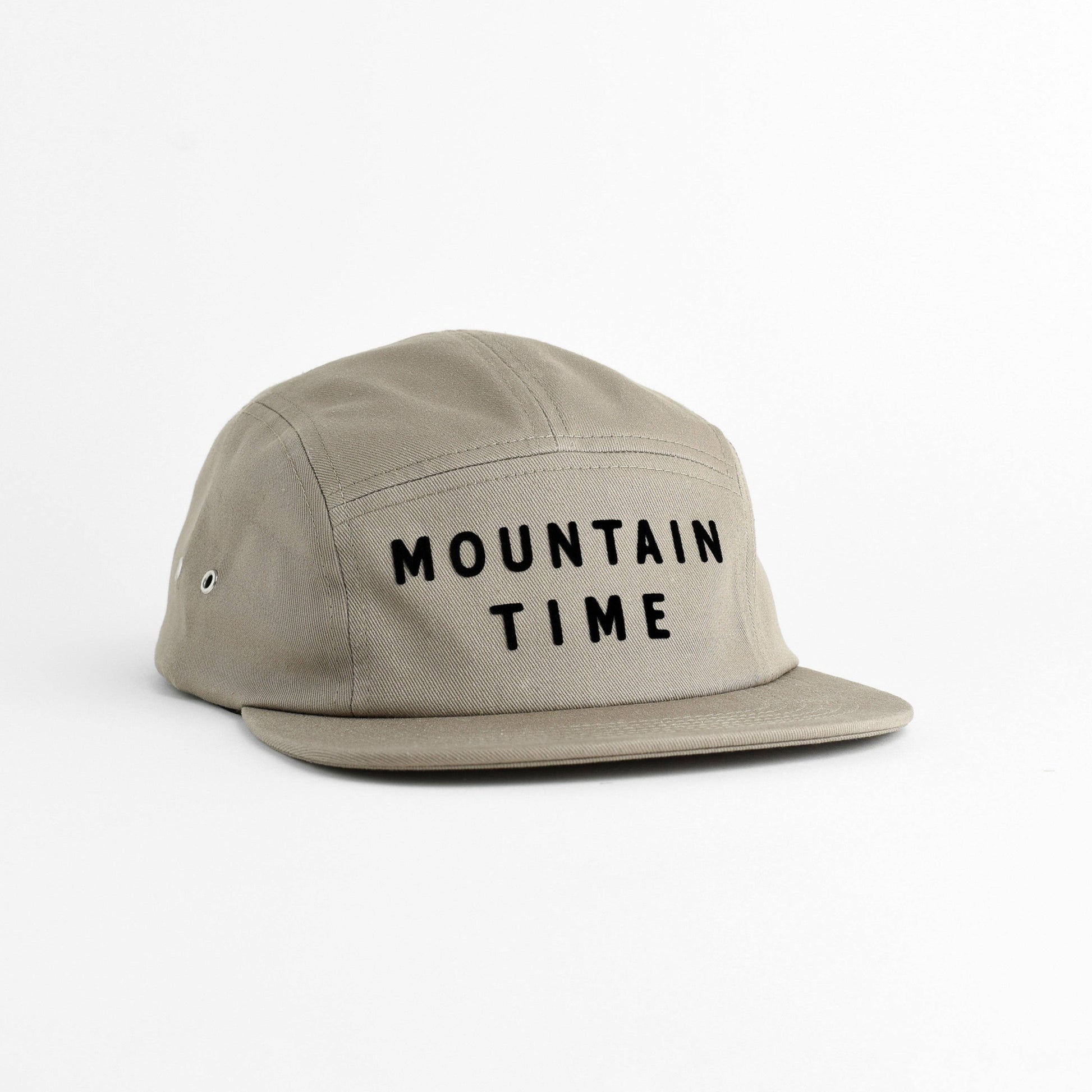 A light khaki five-panel cap with 'MOUNTAIN TIME' embroidered in black across the front, shown on a clean white background.