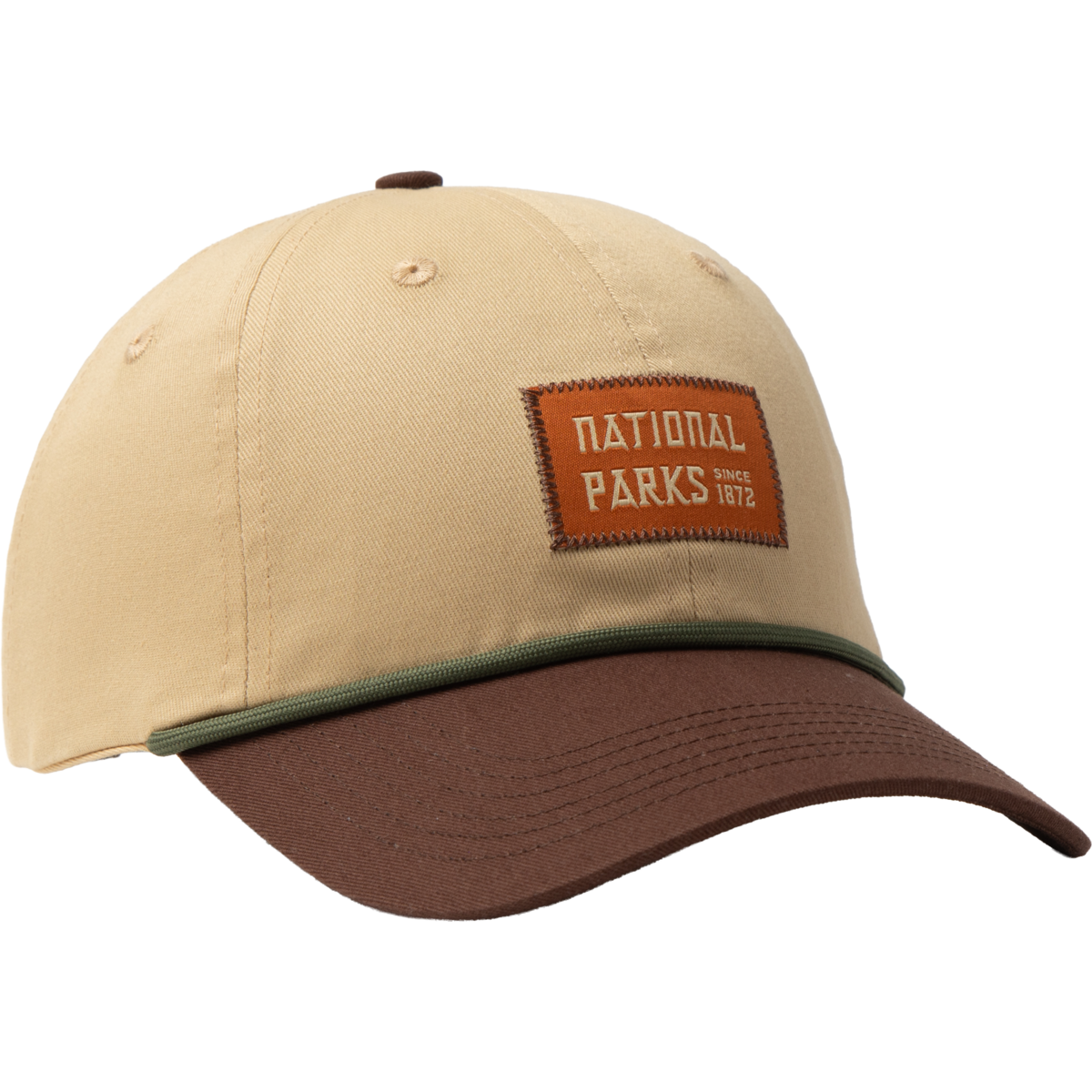 A beige baseball cap with a brown visor, featuring a green piping detail along the bill and a brown leather patch on the front that reads 'NATIONAL PARKS since 1962'.