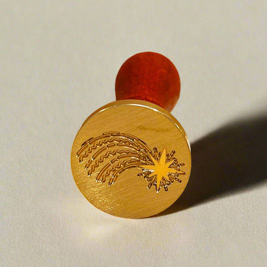 Decorative wooden stamp with a red handle on a beige background