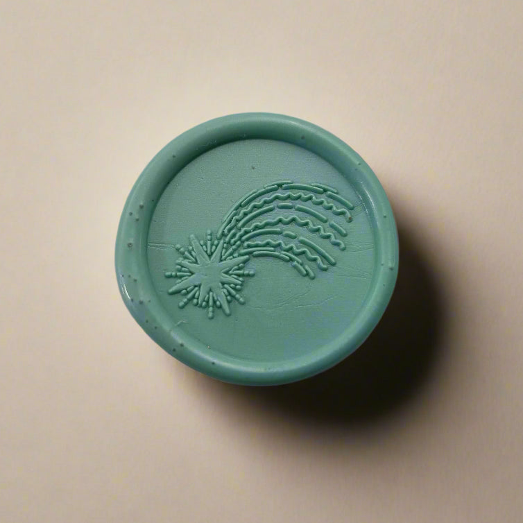 Green rubber stamp with embossed design on a beige background