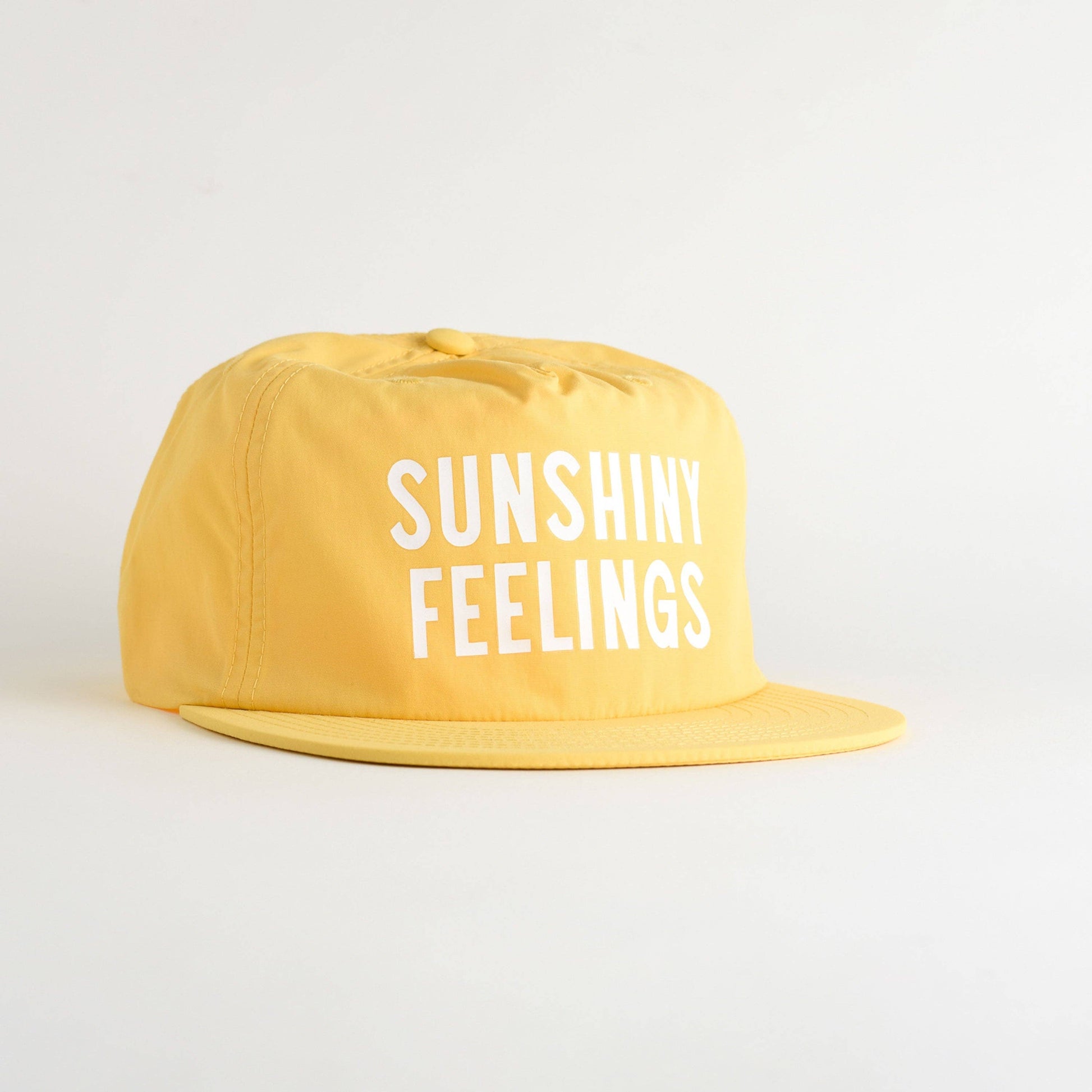 Yellow cap with 'SUNSHINY FEELINGS' text on a light gray background