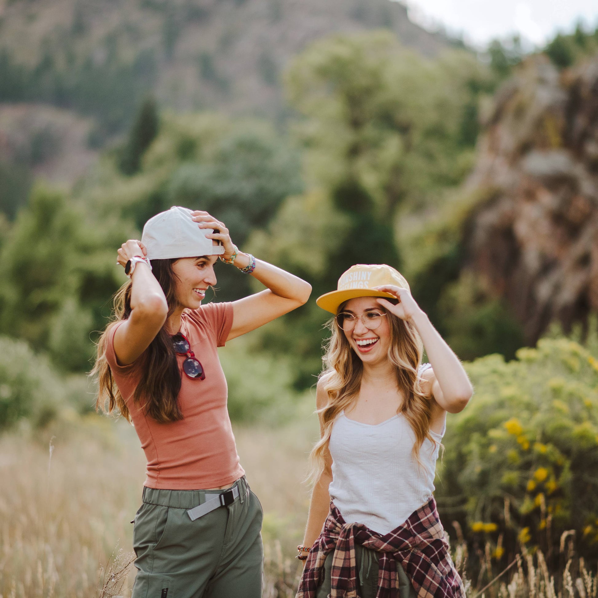 Two women standing in a field with mountains in the background